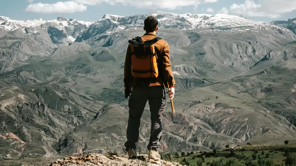 Turista realizando una actividad de aventura en los Andes, rodeado de montañas y paisajes extremos.