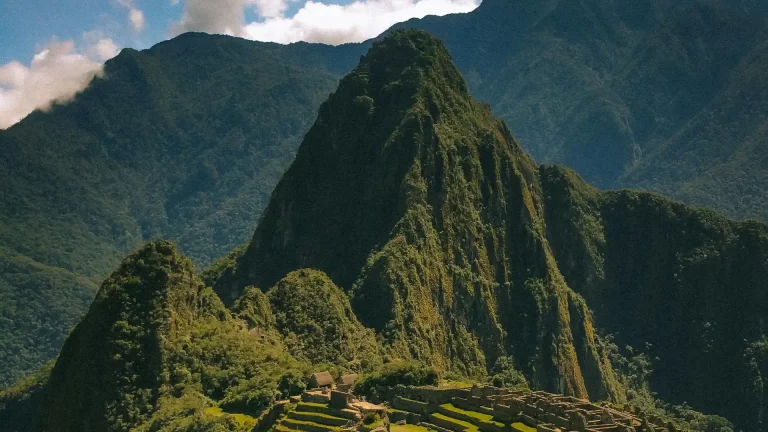 Vista panorámica de Machu Picchu con la montaña Huayna Picchu de fondo, mostrando las terrazas incas y el paisaje andino.